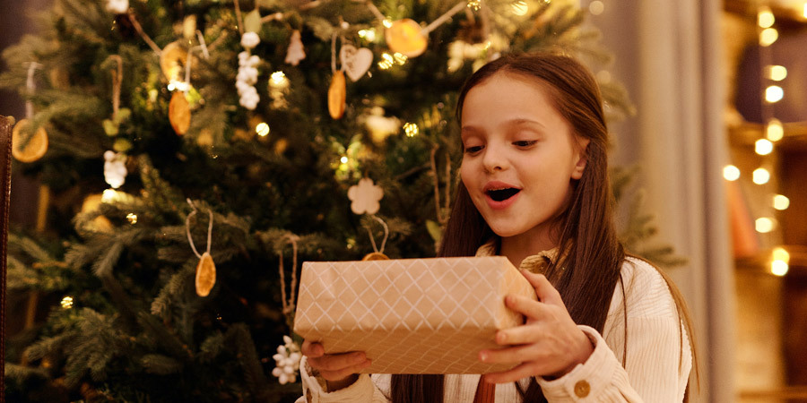 child receiving wrapped present on christmas