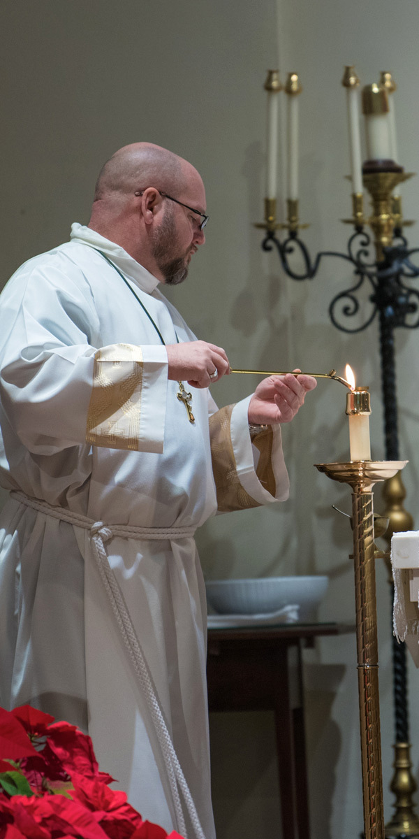 priest lighting candle