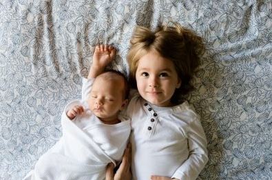 child and baby laying down