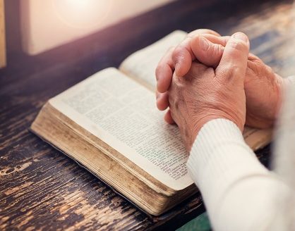 woman praying on bible