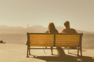man and woman sitting on bench