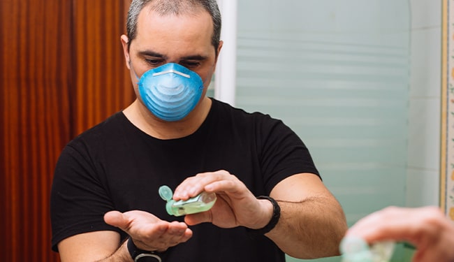 man with hand sanitizer and mask