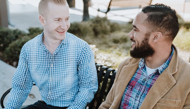 men talking on bench