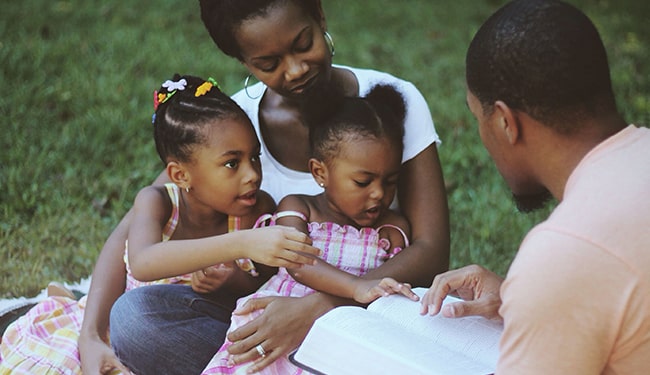 family reading bible outside