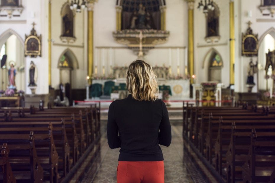 Woman stands in church.