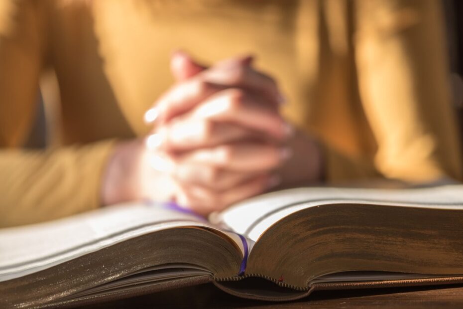 woman praying on bible