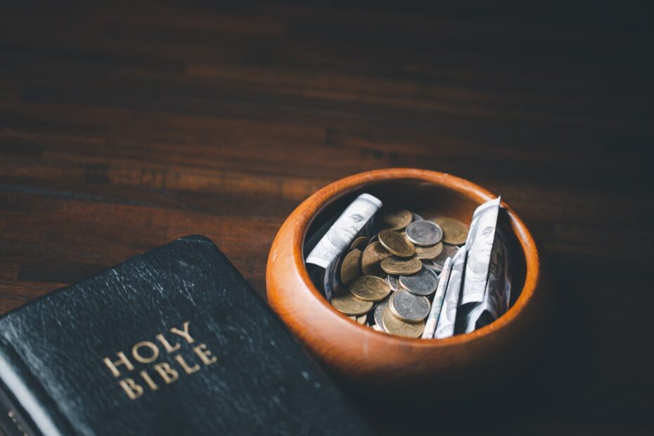 church offering plate full of money next to bible