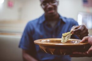 person putting money in church offering plate
