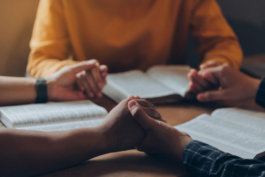 people holding hands during bible study
