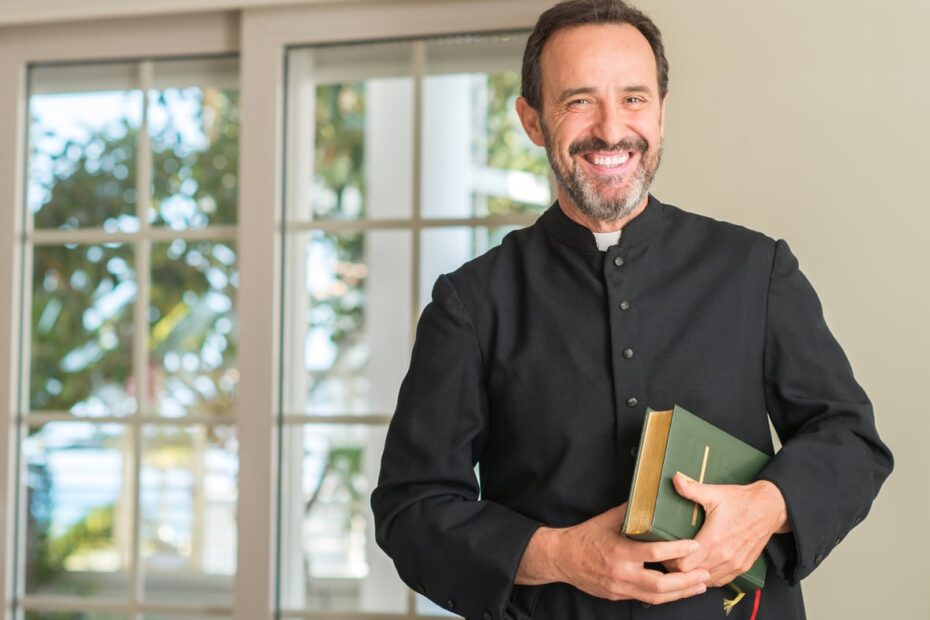 pastor smiling holding green bible