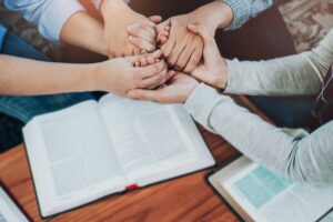 church go-ers holding hands and praying