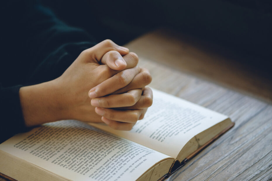 person praying with open bible