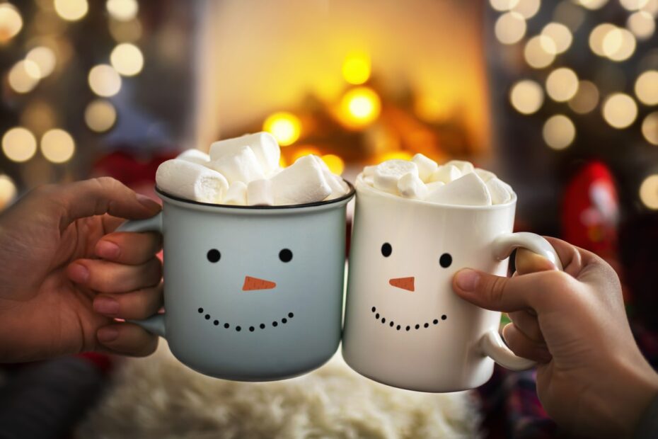 people drinking hot chocolate in front of fire on christmas