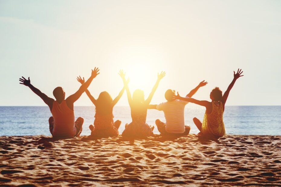 group of young people at beach during sunset