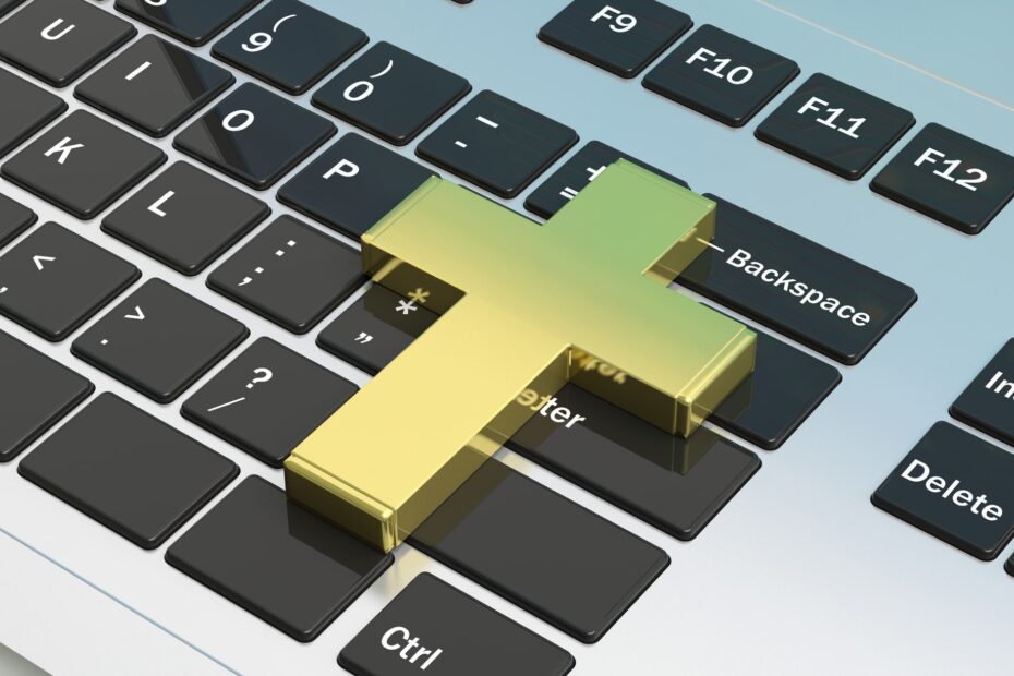 religious cross on top of laptop keyboard