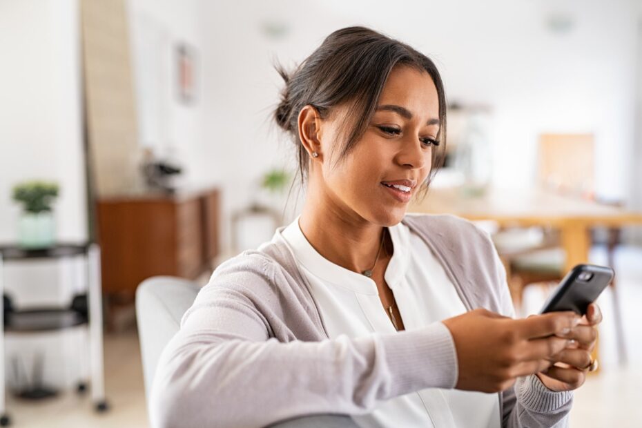 woman smiling and looking at phone