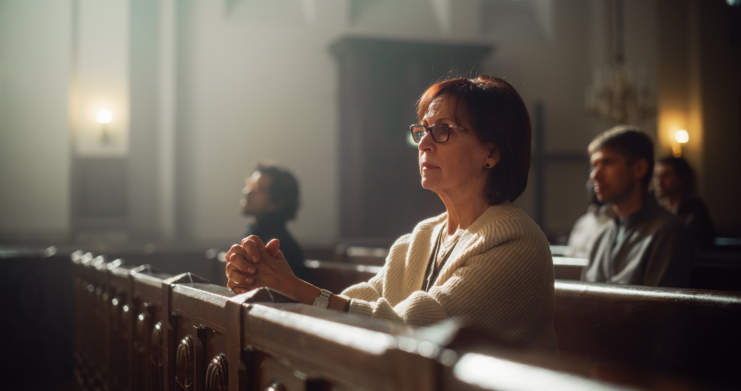 mom praying at church pew