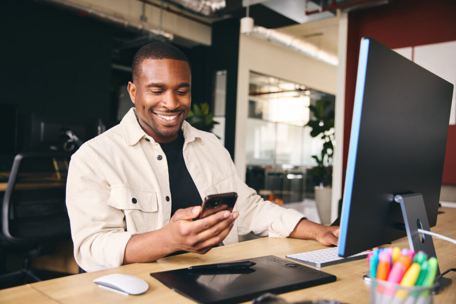 Man smiling at his phone while using text to give software for his church
