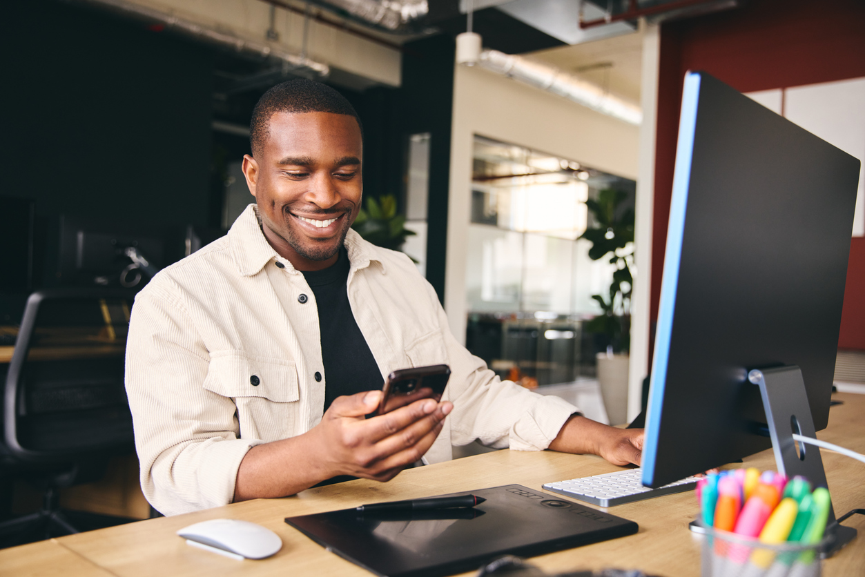 Man smiling at his phone while using text to give software for his church